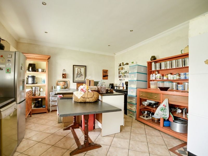 A functional kitchen space featuring tiled flooring, recessed lighting, and ample built-in cabinetry, offering a practical layout for daily culinary activities.
