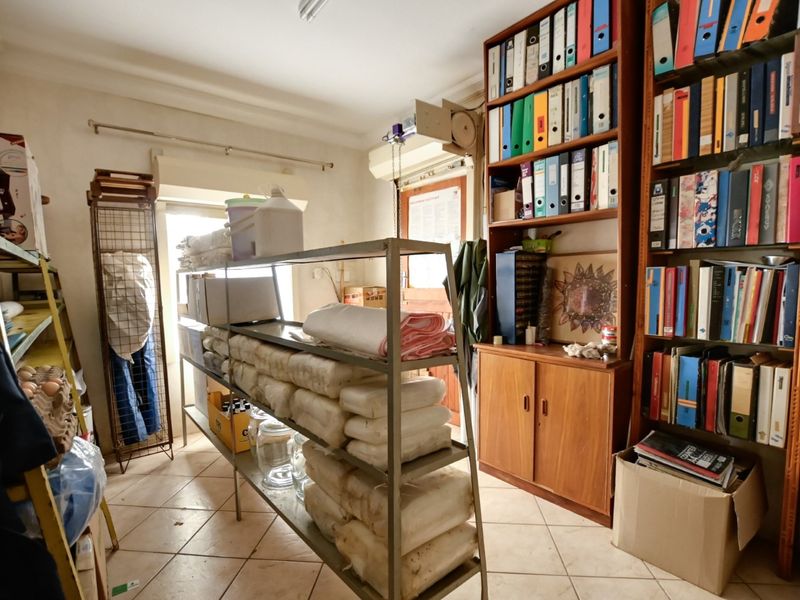A functional utility or storage room featuring tiled flooring and extensive built-in shelving units, suitable for organized storage or workspace requirements.