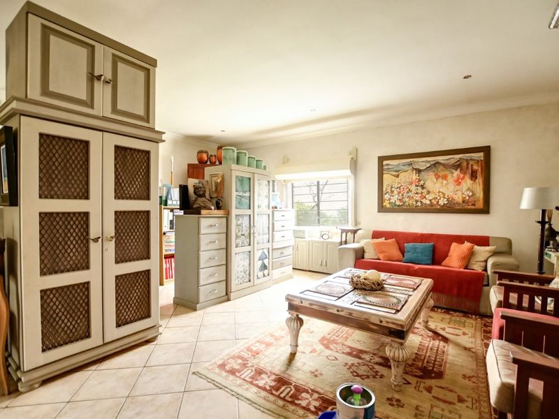 A comfortable living room featuring tiled flooring, recessed lighting, and built-in storage cabinetry, offering a functional and well-lit space.