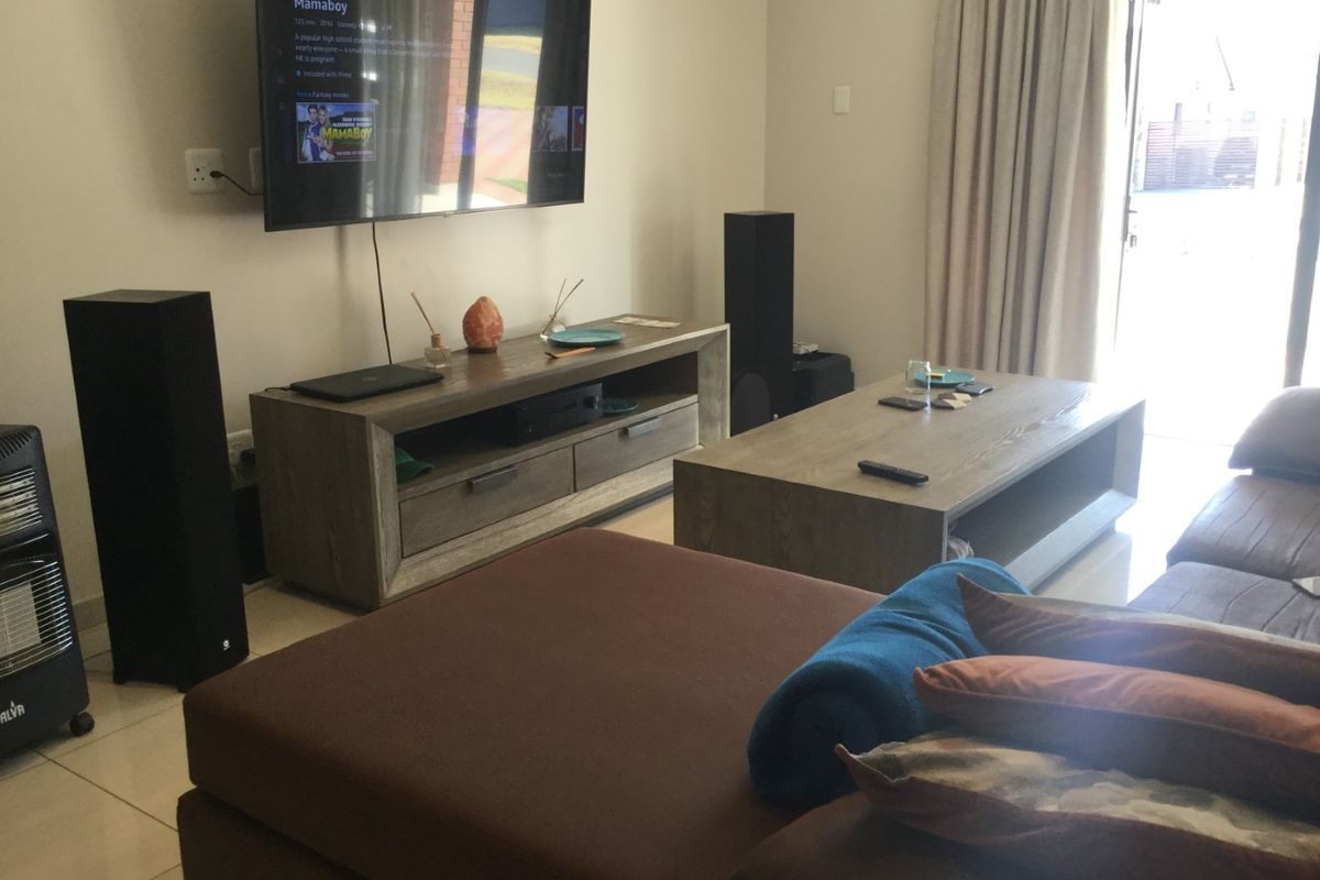 A living room featuring tiled flooring and a sliding glass door leading to an outdoor area.