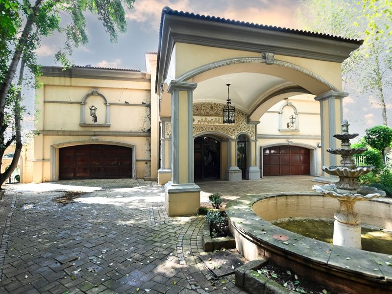Grand front elevation featuring a covered portico, double garage, and a central stone fountain set within a paved driveway area.