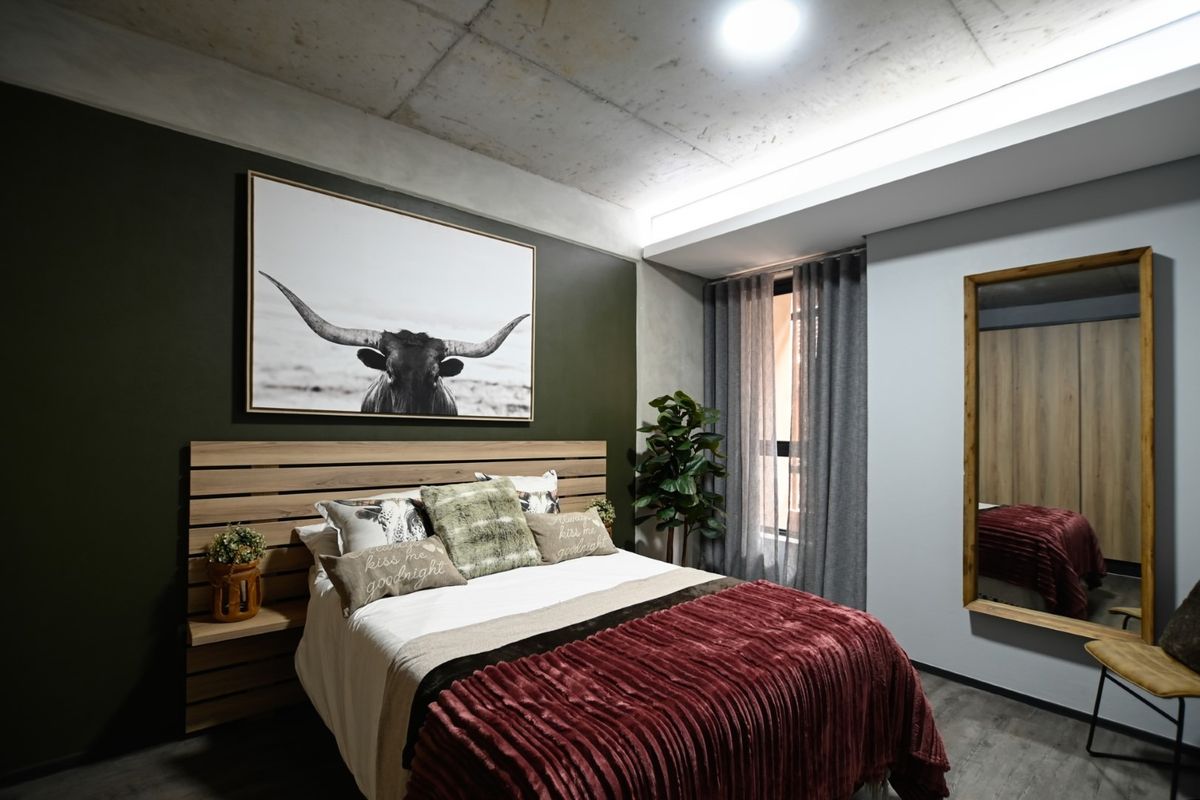 A modern bedroom featuring an exposed concrete ceiling, built-in headboard with integrated shelving, and a built-in wardrobe, creating a stylish and functional living space.