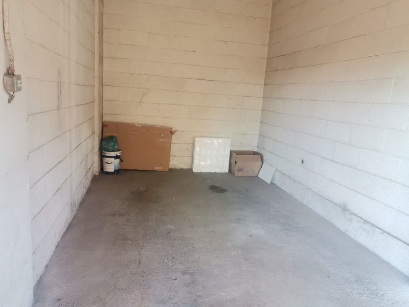 A basic, empty garage space featuring exposed concrete block walls and a concrete floor, suitable for storage or vehicle parking.