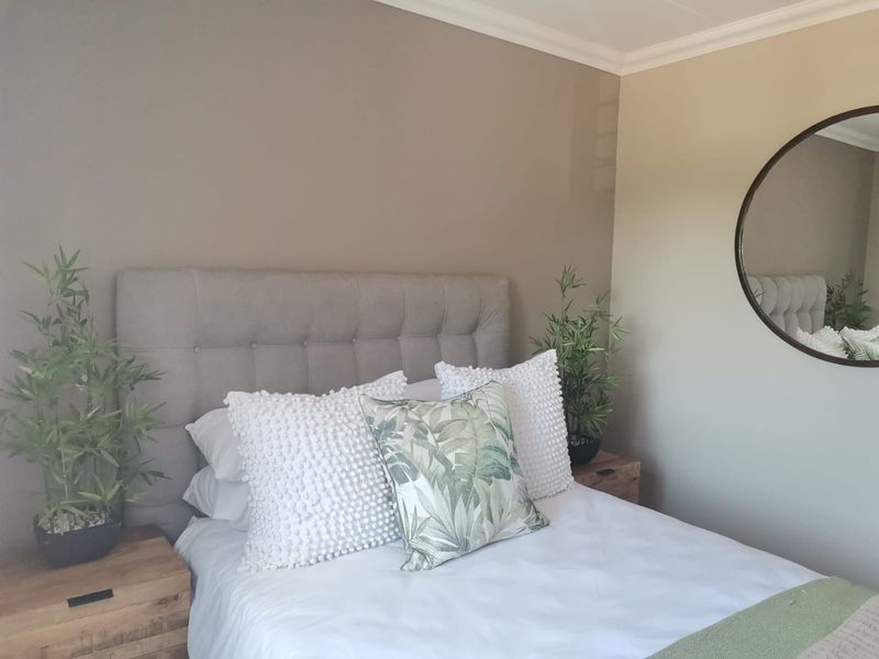 A well-maintained bedroom featuring neutral wall tones and decorative crown molding.