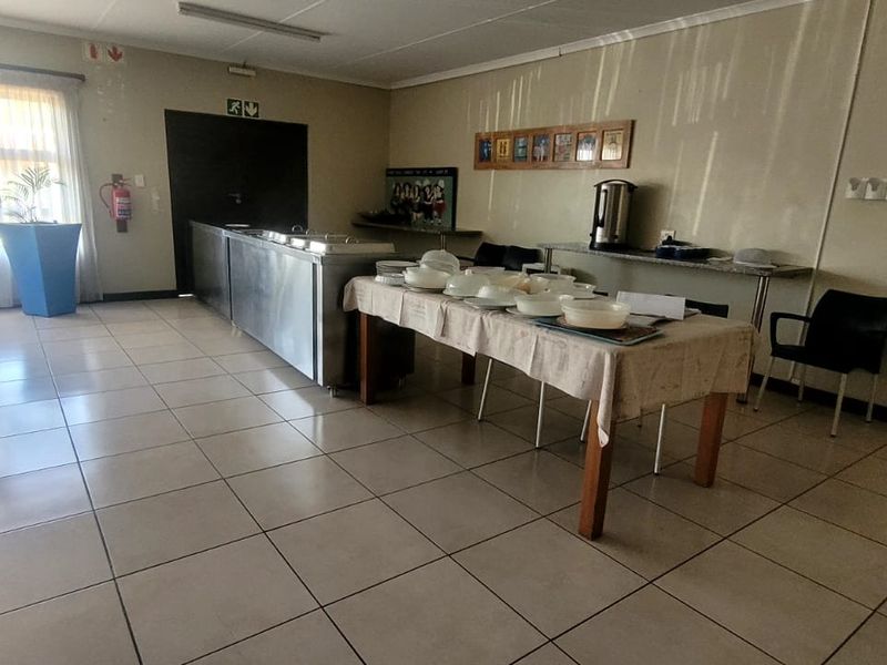 A functional dining area within the retirement village, featuring tiled flooring and basic lighting, suitable for communal meals and social gatherings.