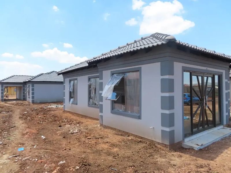 Newly constructed residential house featuring a tiled roof, plastered exterior walls, and aluminium window frames, currently in the final stages of completion.