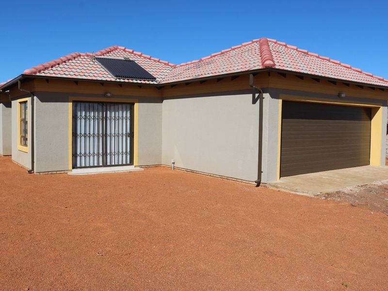 Front exterior view of a single-story house featuring a tiled roof, solar water heater, integrated garage, and a sliding door with security gate.