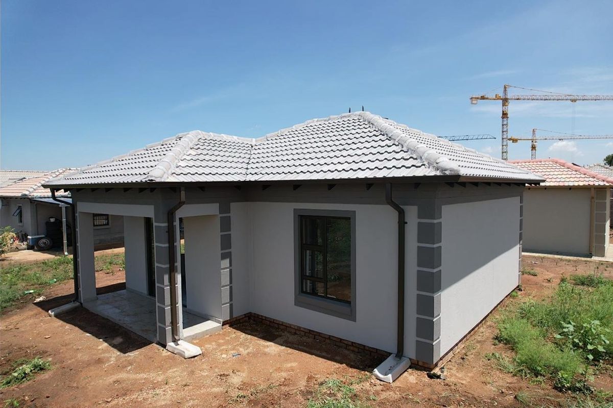 A modern single-story residential house featuring a tiled roof, covered porch, and clean exterior finishes, situated in a developing residential area.