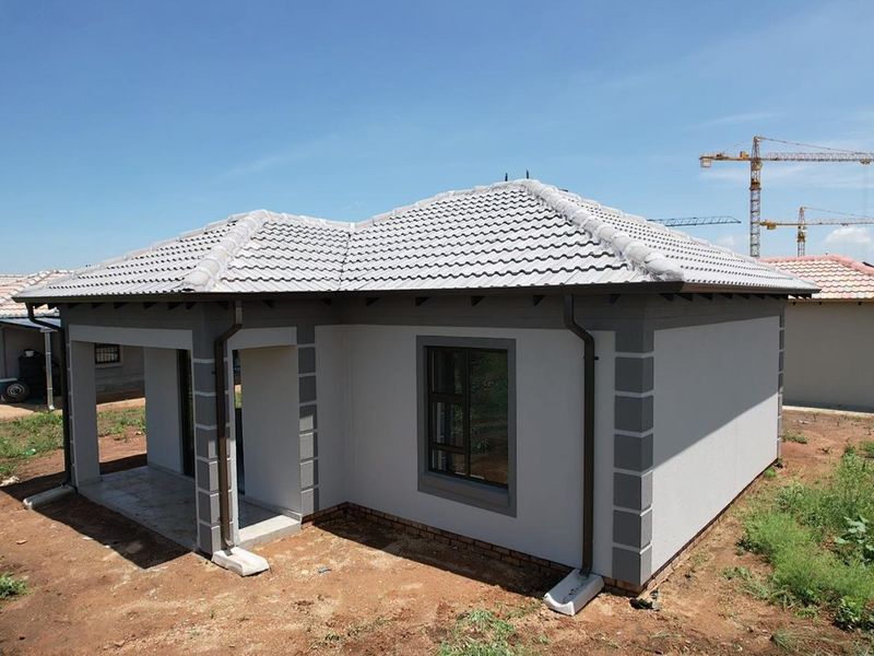 A modern single-story residential house featuring a tiled roof, covered porch, and clean exterior finishes, situated in a developing residential area.