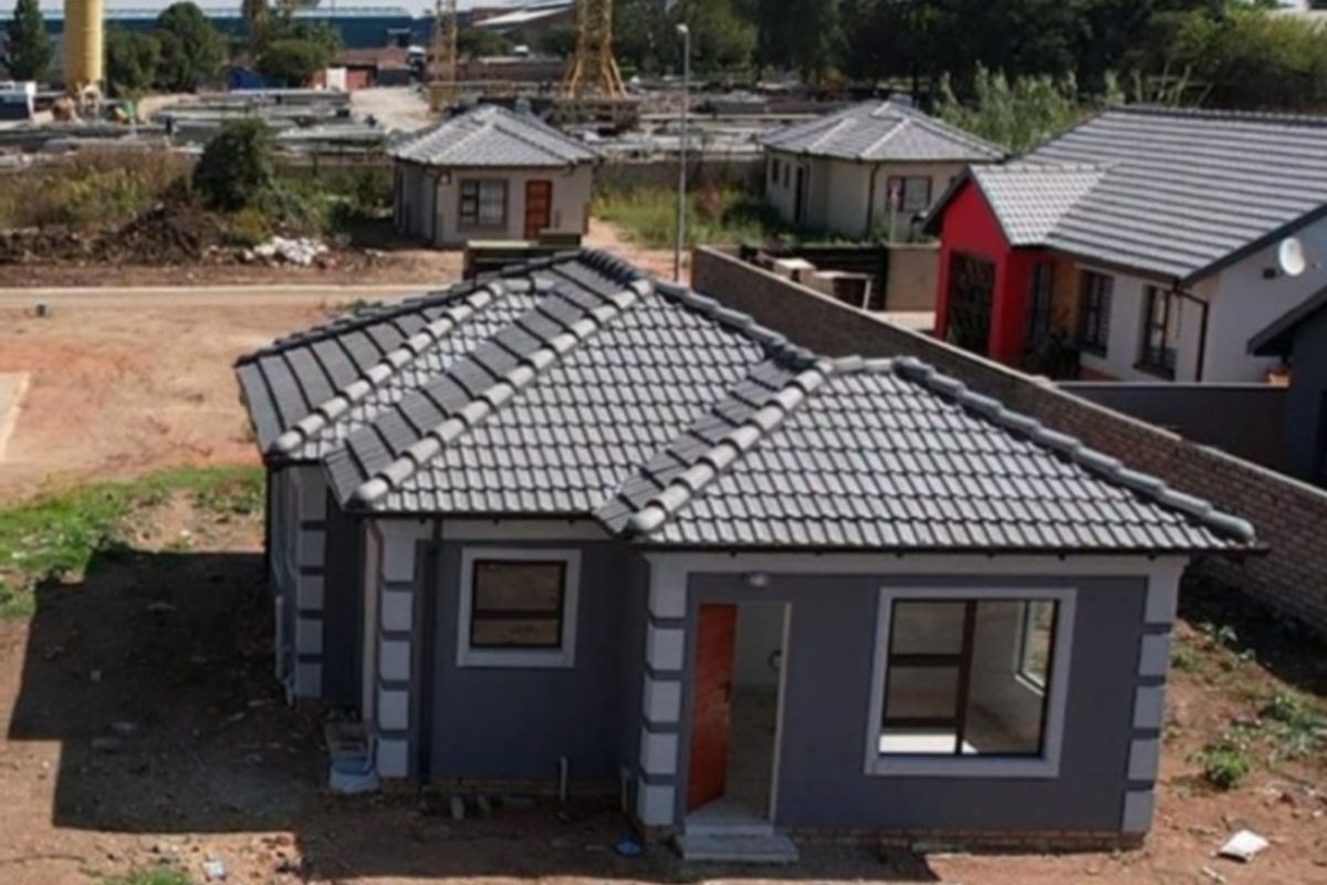 Aerial view of a newly constructed residential house featuring a tiled roof and aluminium window frames, situated in a developing residential estate.