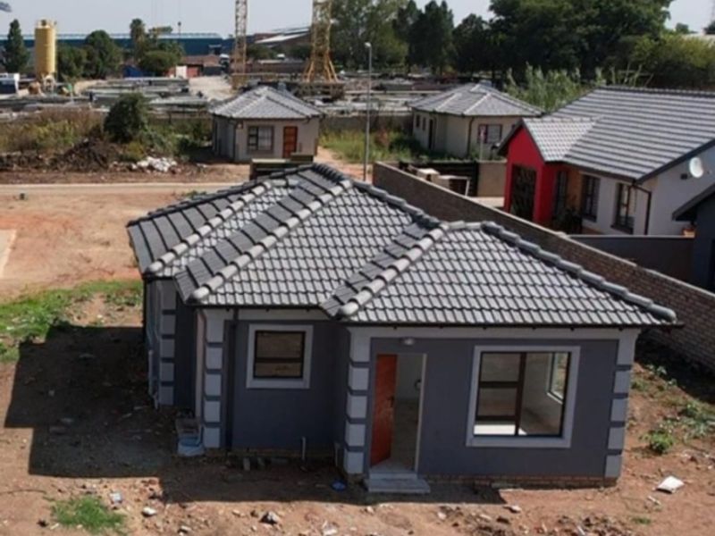 Aerial view of a newly constructed residential house featuring a tiled roof and aluminium window frames, situated in a developing residential estate.