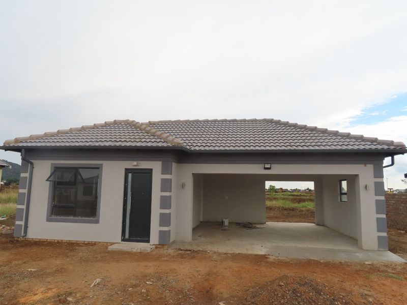 A newly constructed single-story house featuring a tiled roof, integrated garage, and modern grey and white exterior finishes.