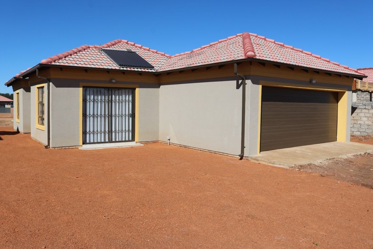 Front exterior view of a single-story house featuring a tiled roof, solar water heater, integrated garage, and a sliding door with security gate.