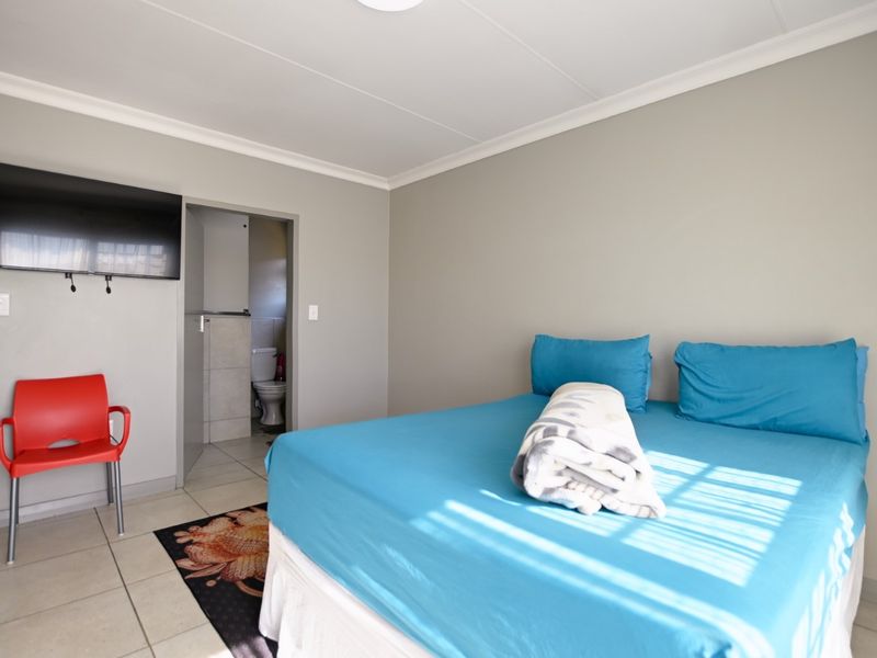 A bedroom featuring tiled flooring, coved ceilings, and an attached en-suite bathroom.