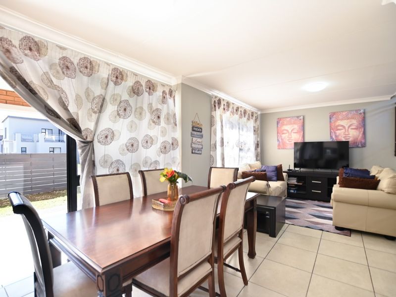 Open plan living and dining area featuring tiled flooring and large sliding glass doors providing access to the exterior.