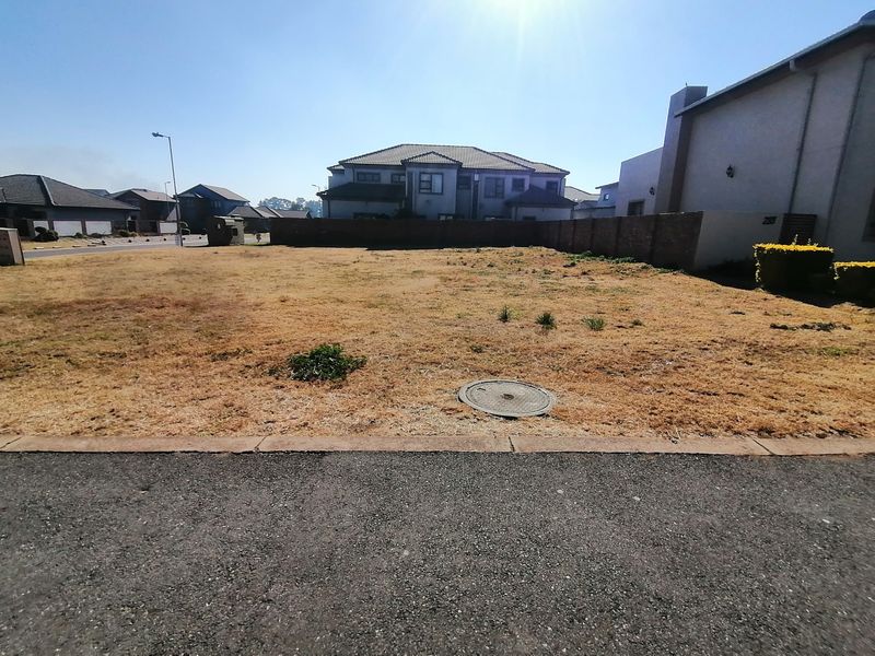 A vacant residential plot featuring a brick boundary wall and direct street access, ready for development in a established neighborhood.