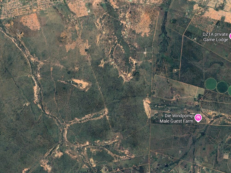 An aerial satellite view of the farm property and surrounding landscape, showing regional terrain and nearby landmarks.