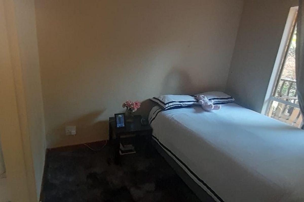A bedroom featuring a large window and an en-suite bathroom with a pedestal basin.