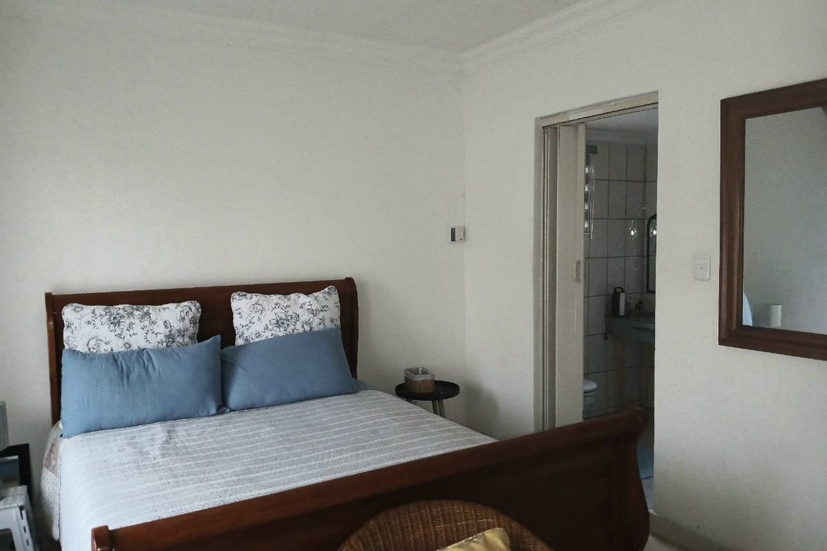 A bedroom featuring neutral walls, coving, and direct access to an en-suite bathroom through a sliding door.