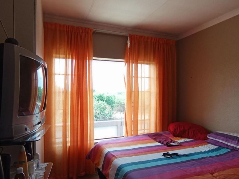 A standard bedroom featuring a window with natural light and built-in storage space.