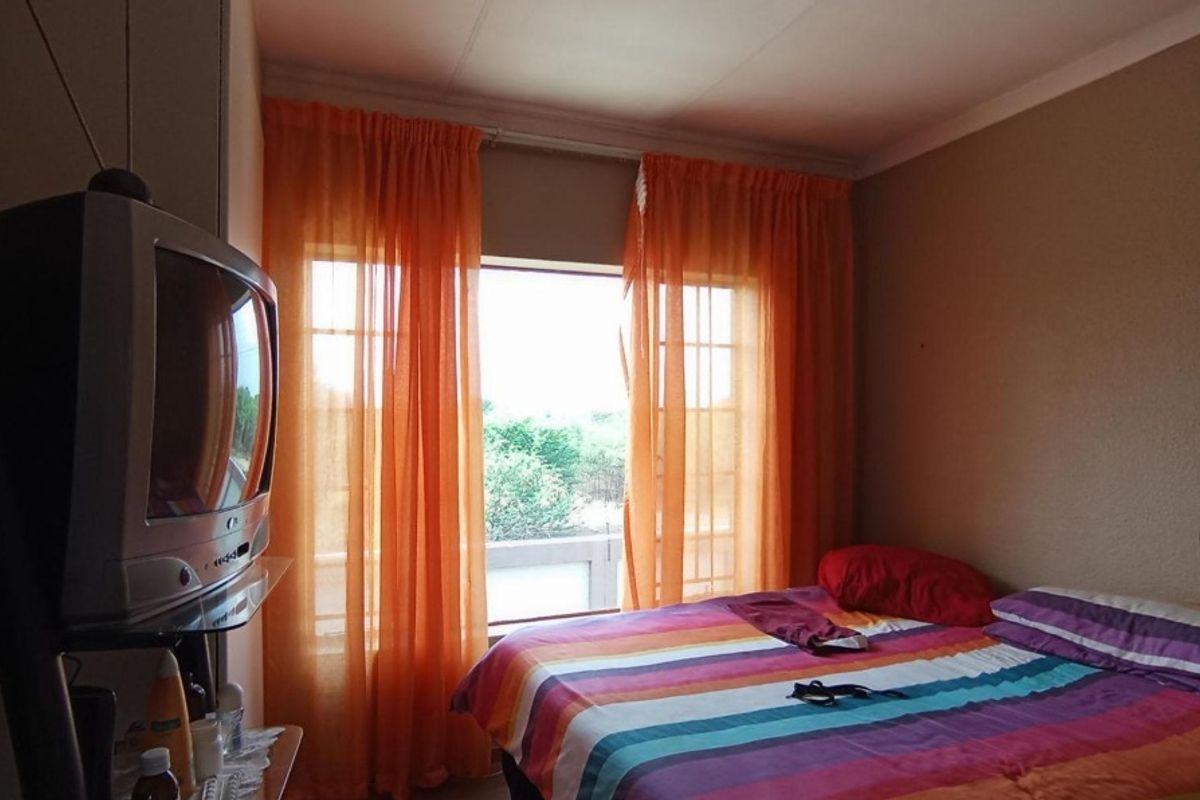 A standard bedroom featuring a window with natural light and built-in storage space.