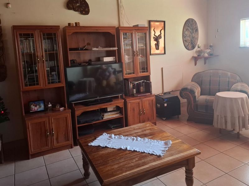 A living room featuring tiled flooring and a window, providing a functional space for relaxation.