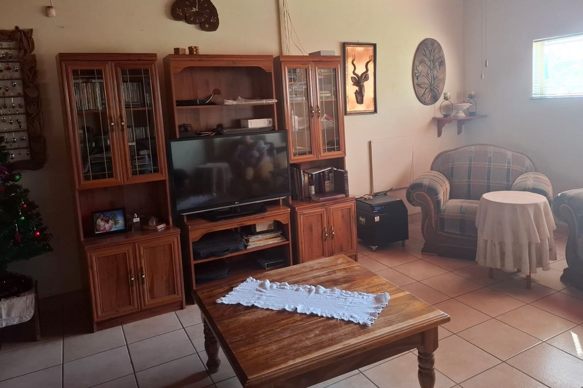 A living room featuring tiled flooring and a window, providing a functional space for relaxation.