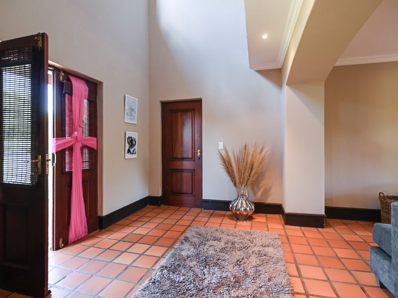 Welcoming entrance hall featuring classic terracotta floor tiles, high ceilings, and solid timber door finishes, creating a warm and inviting transition space.