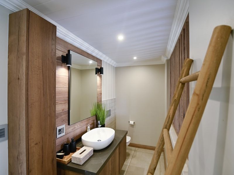 Modern bathroom featuring a vessel sink on a stone vanity, wood-look wall paneling, recessed lighting, and high-quality finishes throughout.