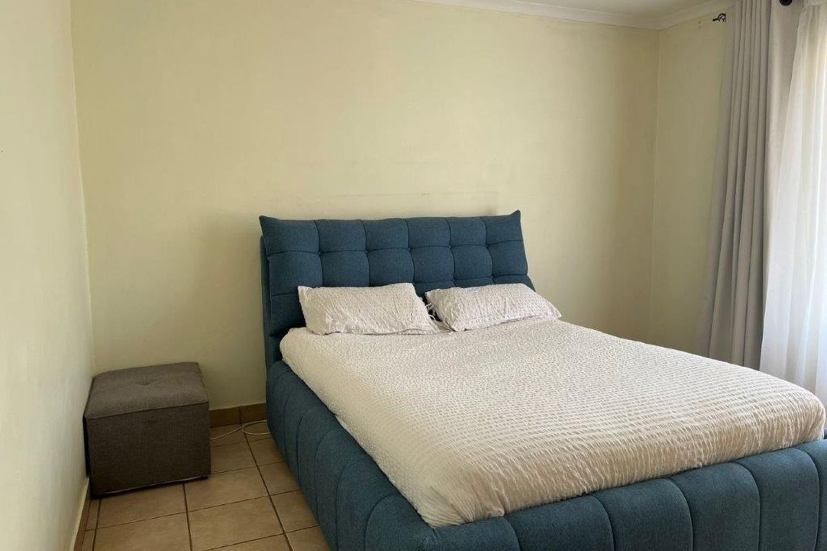 A simple bedroom featuring tiled flooring and neutral wall finishes, providing a functional space for rest.