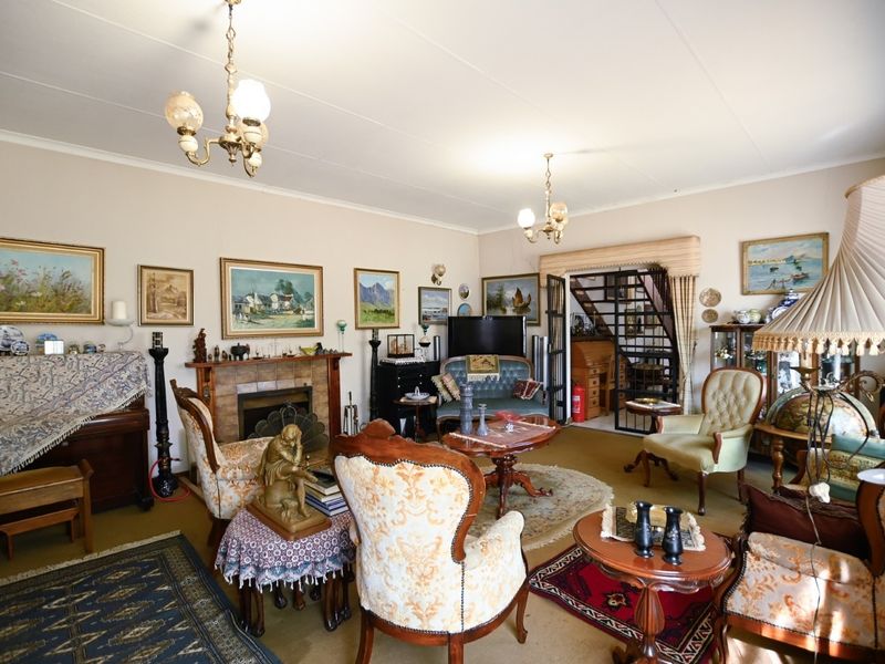 A traditional living room featuring a fireplace with a mantelpiece and access to an adjacent area through a security gate.