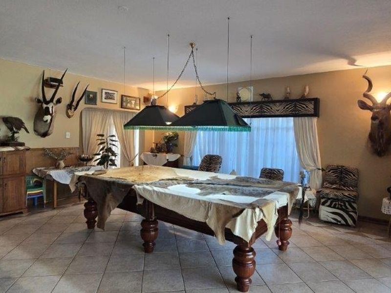 Spacious living area featuring tiled flooring and neutral wall tones, offering a versatile layout suitable for various entertainment or recreational uses.