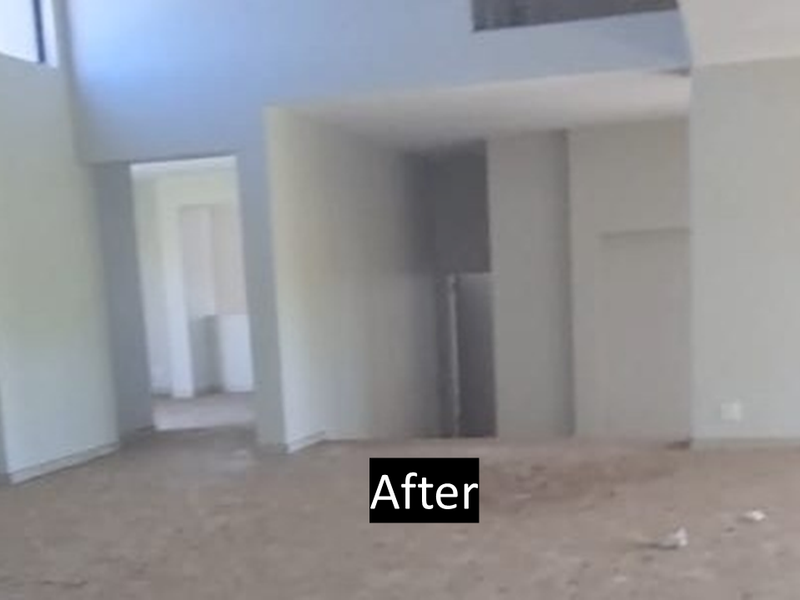 An empty, double-volume living area featuring a staircase and unfinished flooring, offering a blank canvas for interior design and renovation.