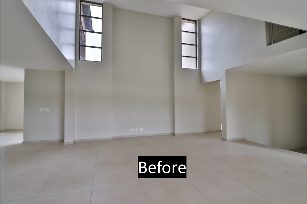 Spacious, light-filled living area featuring double-volume ceilings, large vertical windows, and neutral tiled flooring, offering a versatile open-plan layout.