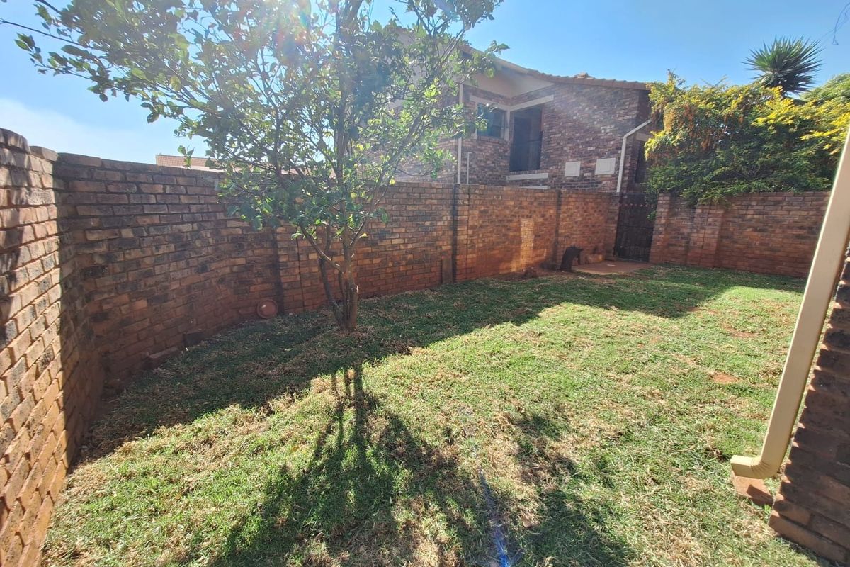 A private rear garden featuring a well-defined lawn area enclosed by sturdy brick boundary walls.