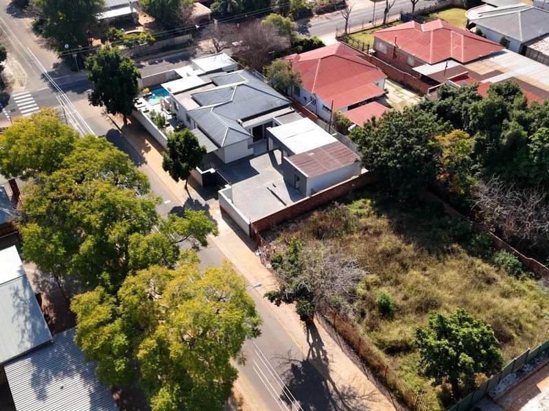 Aerial view of the property showing the main house, swimming pool, driveway, and surrounding residential plot layout.