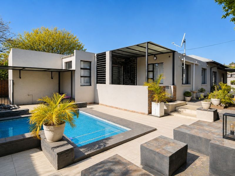 Rear exterior view featuring a swimming pool, tiled patio area, and covered outdoor space with modern architectural lines.
