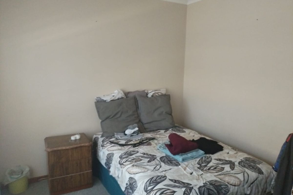 A standard bedroom featuring neutral wall paint, carpeted flooring, and coved ceiling detailing.