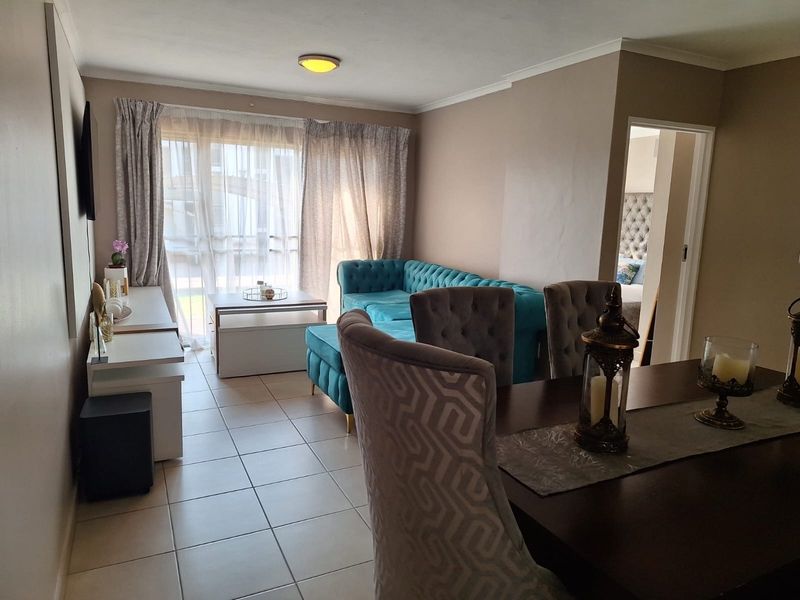 Open plan living and dining area featuring tiled flooring and a sliding glass door providing access to the exterior.