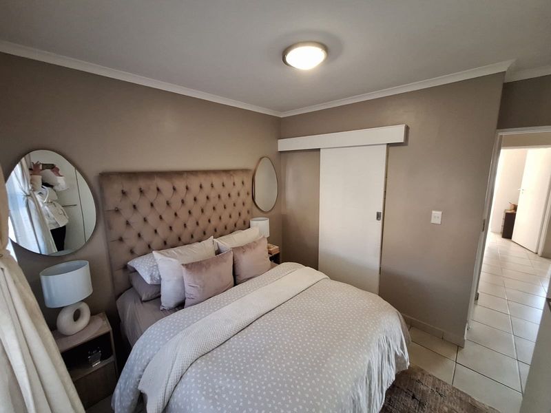 A well-maintained bedroom featuring a sliding door and neutral wall tones, providing a comfortable and functional living space.