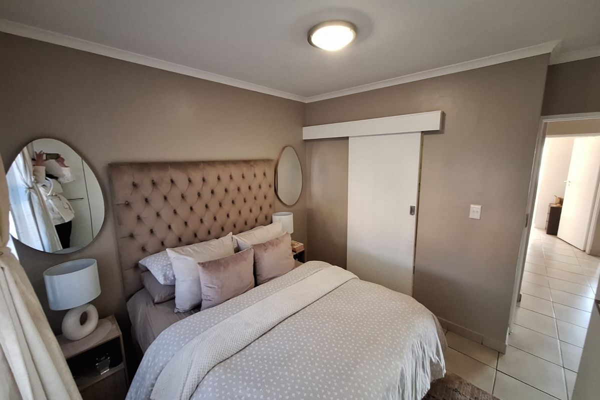 A well-maintained bedroom featuring a sliding door and neutral wall tones, providing a comfortable and functional living space.