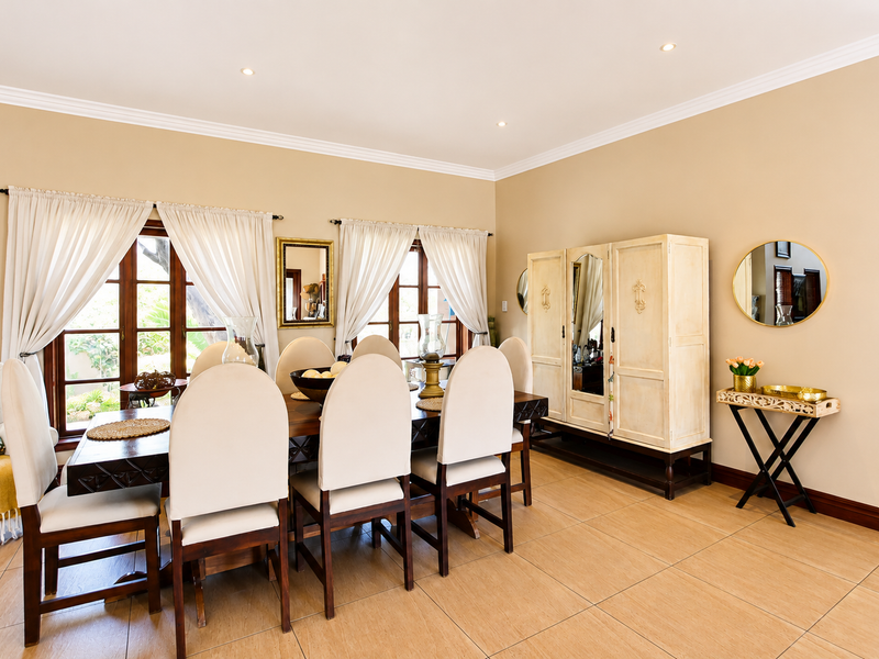A well-maintained dining room featuring tiled flooring, recessed downlighting, crown molding, and timber-framed windows that provide natural light.
