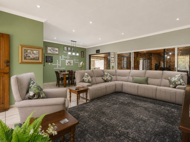 Spacious open-plan living and dining area featuring tiled floors, recessed lighting, and large sliding glass doors providing access to the outdoor space.