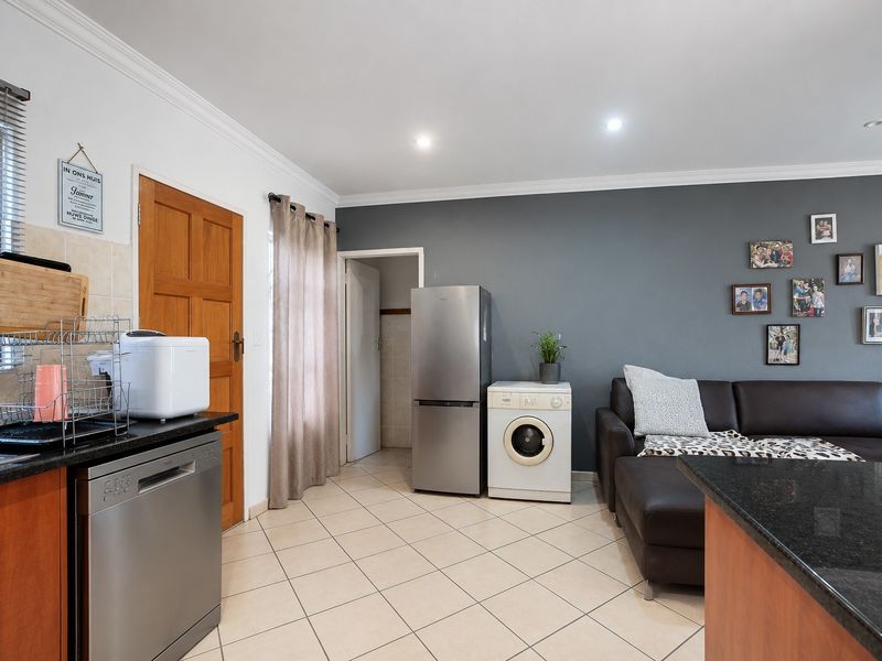 Open plan living area featuring tiled flooring, granite countertops, and recessed lighting, seamlessly connecting the kitchen and lounge space.