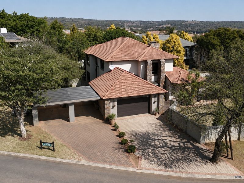 Aerial view of a double-story residential property featuring a tiled roof, paved driveway, double garage, and an attached carport.