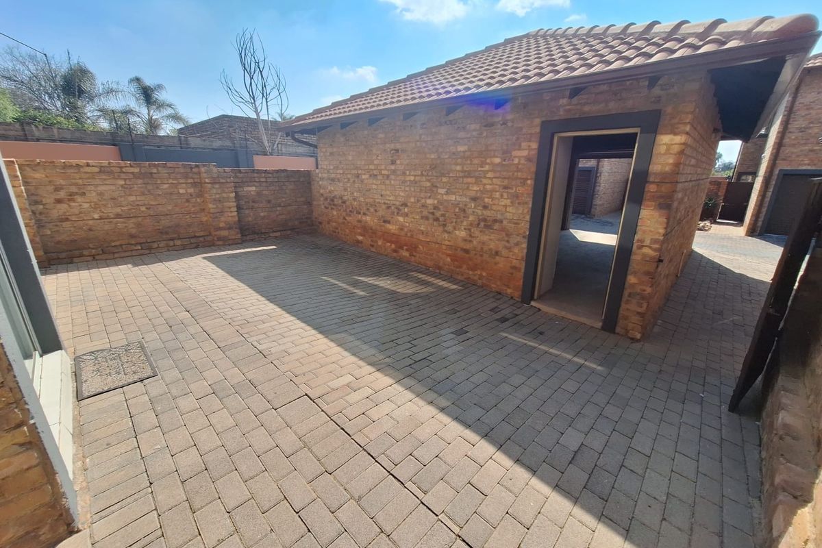 A private rear courtyard featuring durable brick paving and face brick exterior walls, providing a low-maintenance outdoor space.