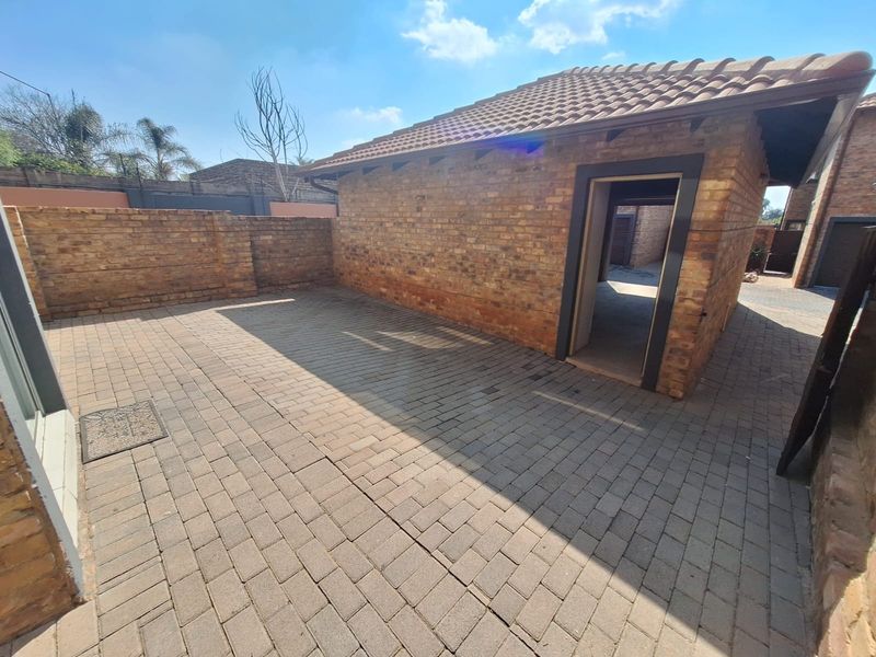 A private rear courtyard featuring durable brick paving and face brick exterior walls, providing a low-maintenance outdoor space.