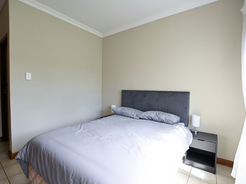 A standard bedroom featuring neutral wall paint, tiled flooring, and decorative coving, providing a clean and functional space.