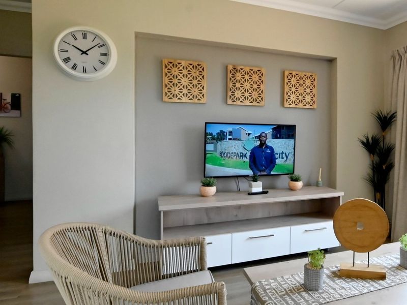 A well-maintained living room featuring a recessed wall niche designed for media placement, complemented by neutral wall tones and classic cove cornicing.