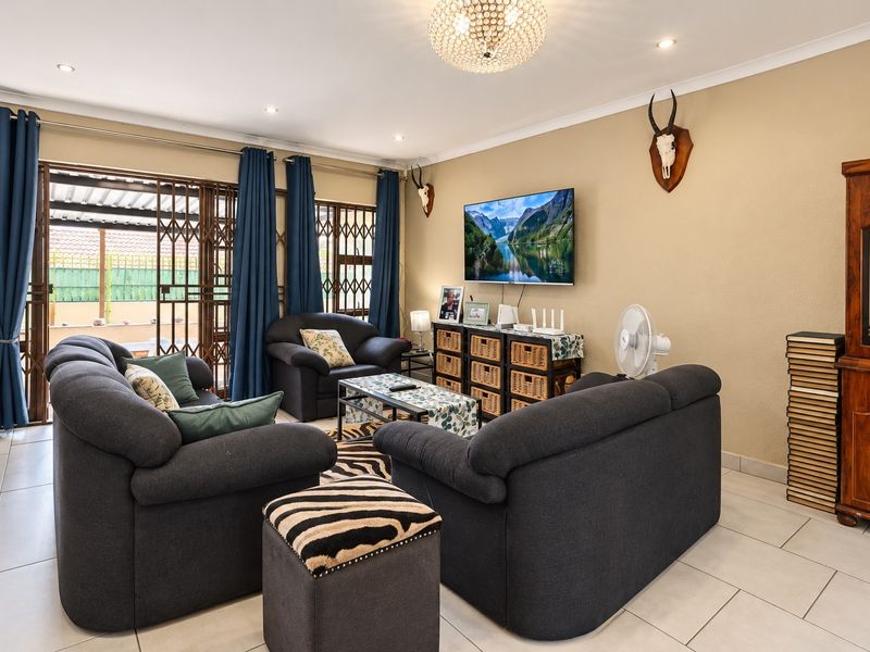 A comfortable living room featuring tiled flooring, recessed lighting, and sliding glass doors that provide access to the outdoor area.